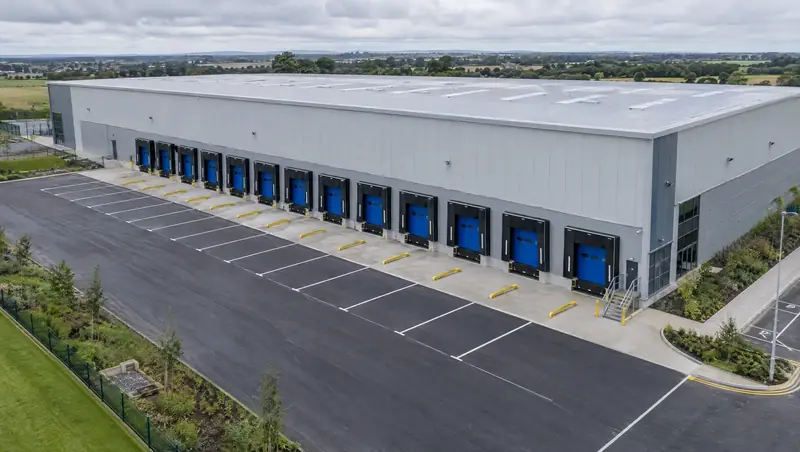 Aerial view of a new warehouse with a row of blue loading dock doors